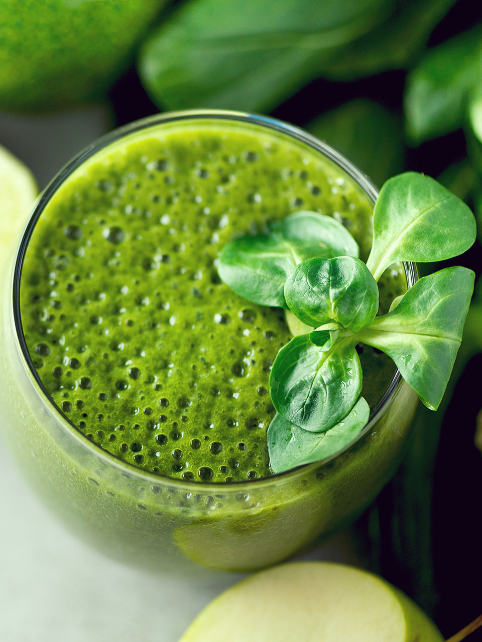 Glass with green health smoothie, kale leaves, lime, apple, kiwi, grapes, banana, avocado, lettuce. Copy space. Raw, vegan, vegetarian, alkaline food concept